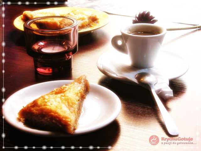 Kawa, baklawa na talerzu, świeca na stole